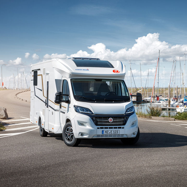 Ein weißes Wohnmobil steht am Straßenrand.