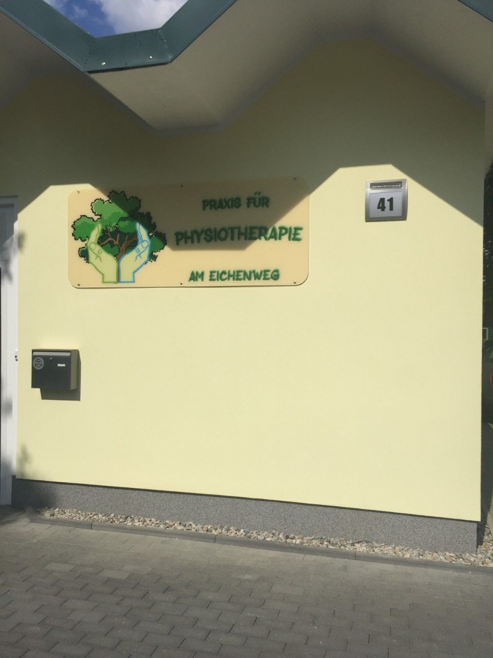 Schild auf der Hauswand der Praxis