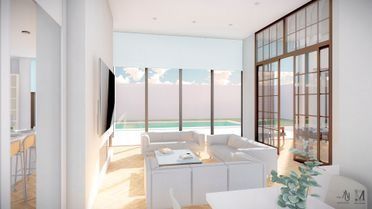 Luminoso salón moderno con muebles blancos, grandes ventanales y vistas al mar.