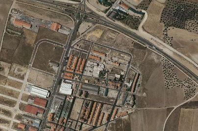 Vista aérea de un complejo industrial con edificios, carreteras y campos circundantes.