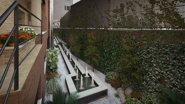 Escalera exterior moderna junto a un muro y edificio cubiertos de enredaderas.