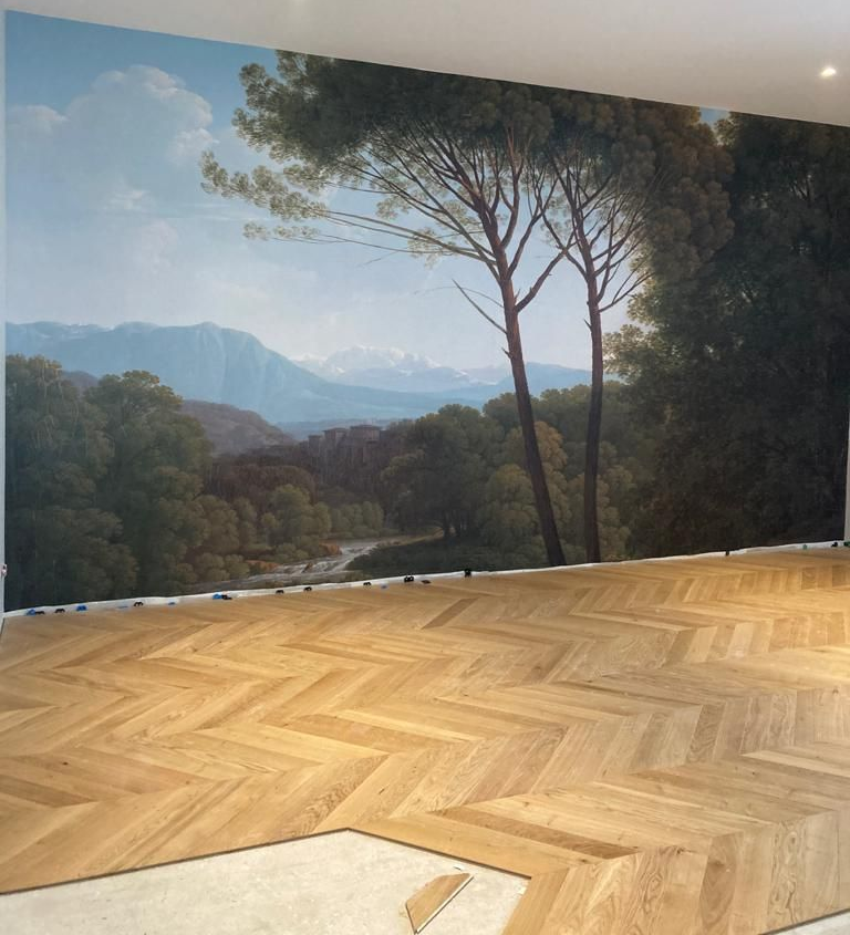 Peinture murale représentant une scène de paysage avec des montagnes et des arbres.