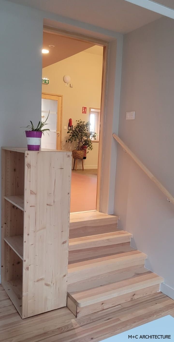 Escalier en bois menant à la porte, doté d'une bibliothèque et d'une rampe.