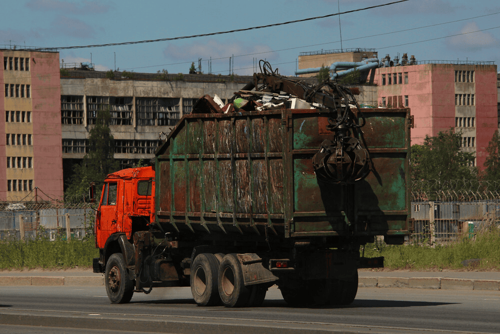 Un camión de basura circula por una calle de la ciudad.