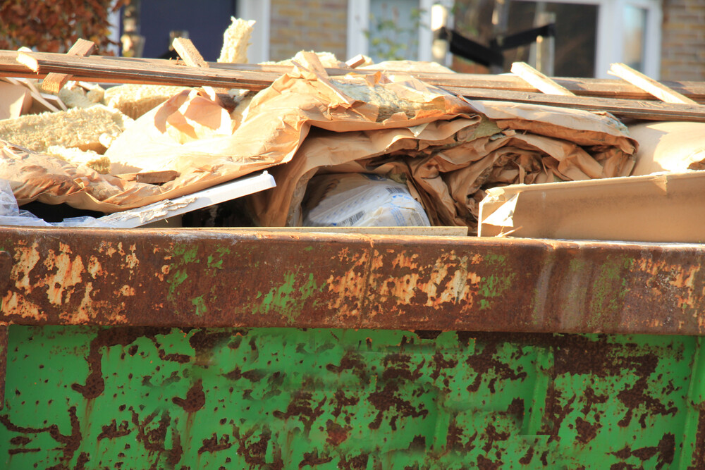 Un contenedor verde lleno de basura.