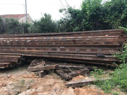 Una pila de madera se encuentra encima de un campo de tierra.