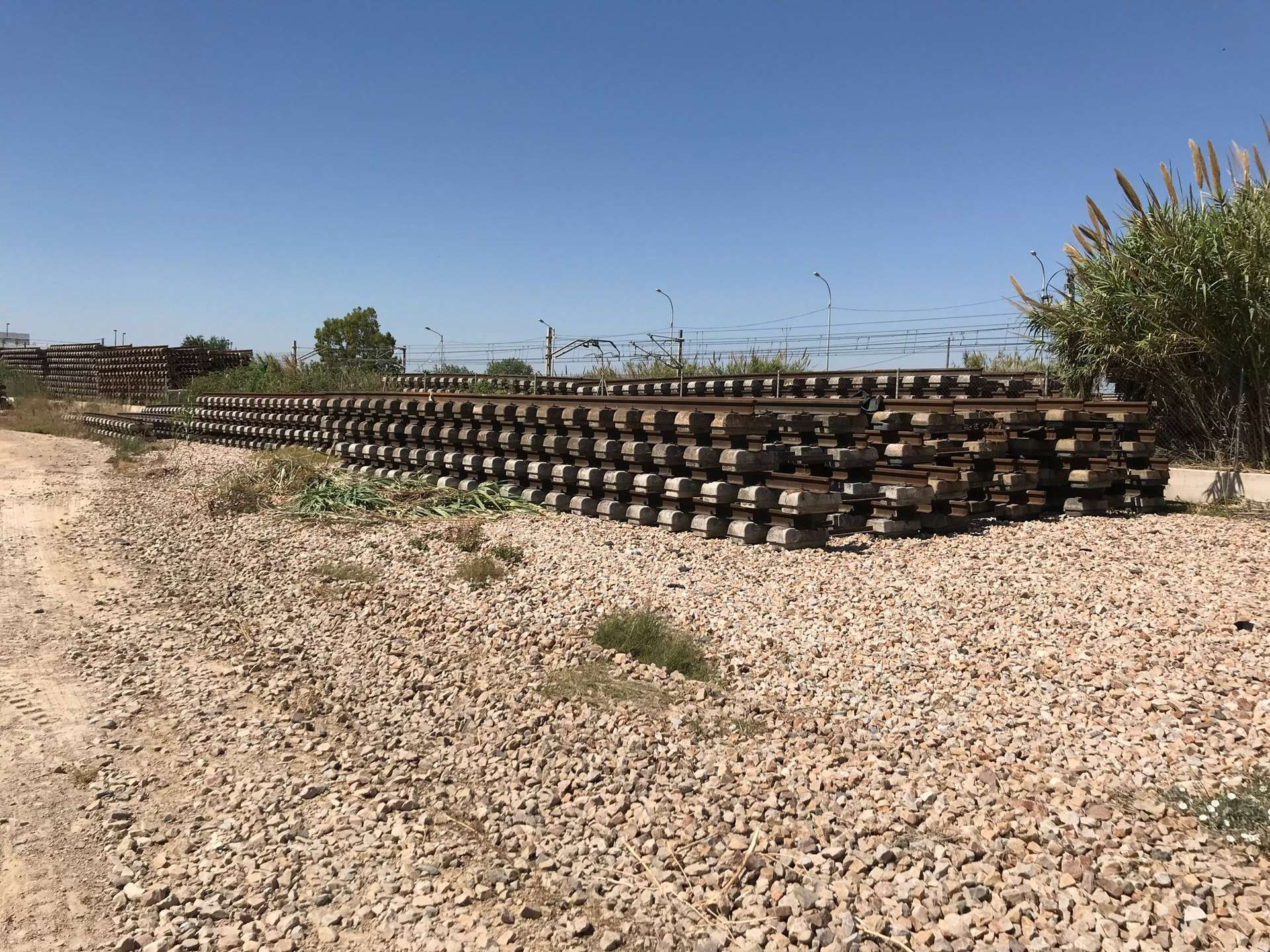 Una pila de vías de tren están apiladas una encima de otra en un camino de grava.
