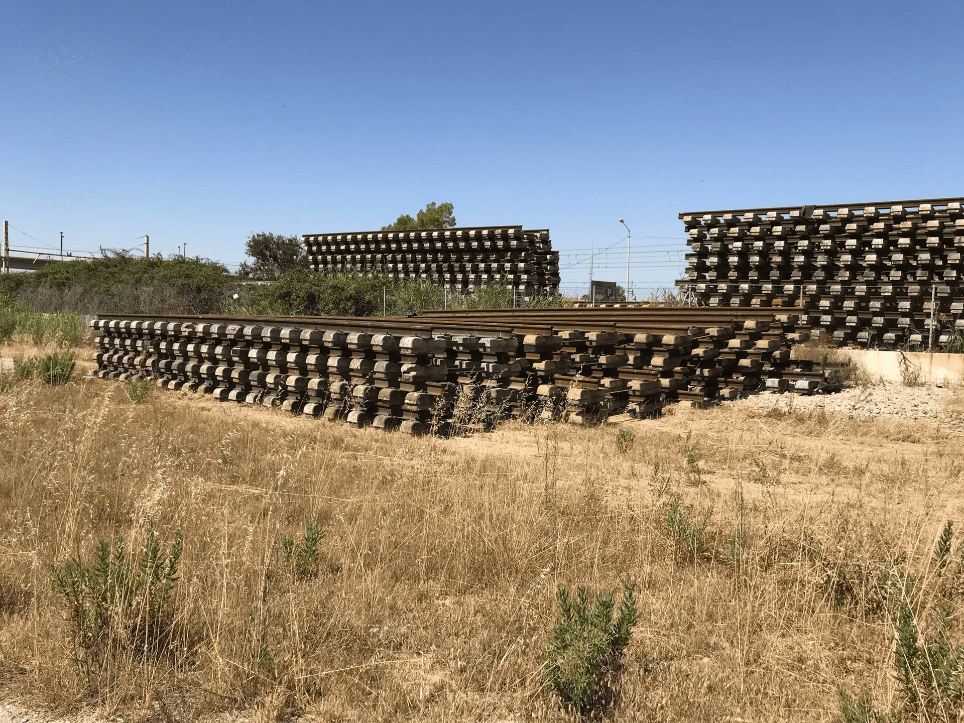Un montón de vías de tren están apiladas una encima de otra en un campo.