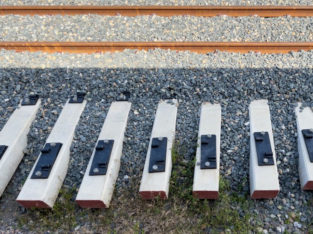 Una fila de bloques de hormigón están alineados al lado de una vía de tren.