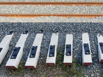 Una fila de bloques de hormigón están alineados al lado de una vía de tren.
