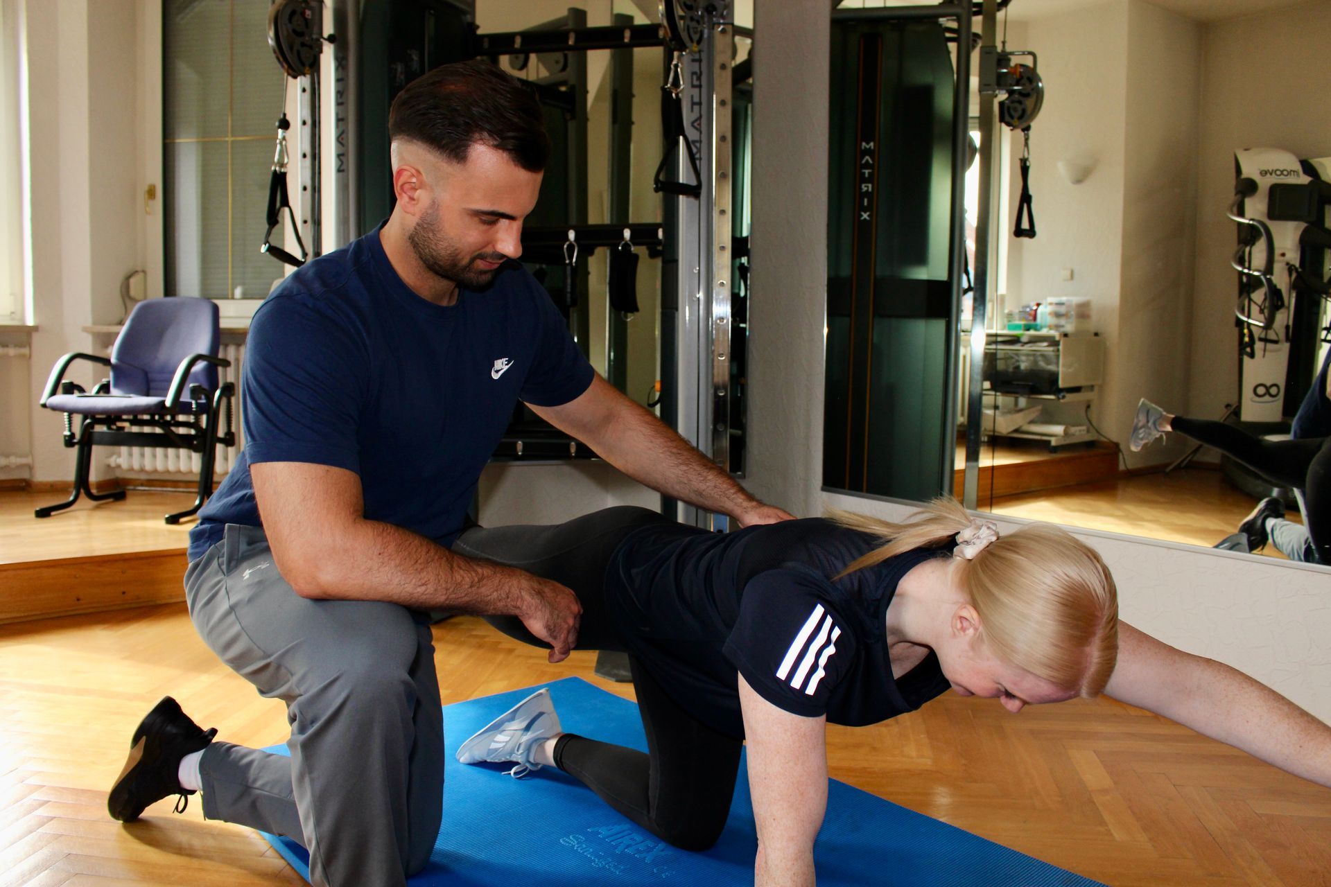 Ein Personaltrainer berät einen Kunden im Fitnessstudio.