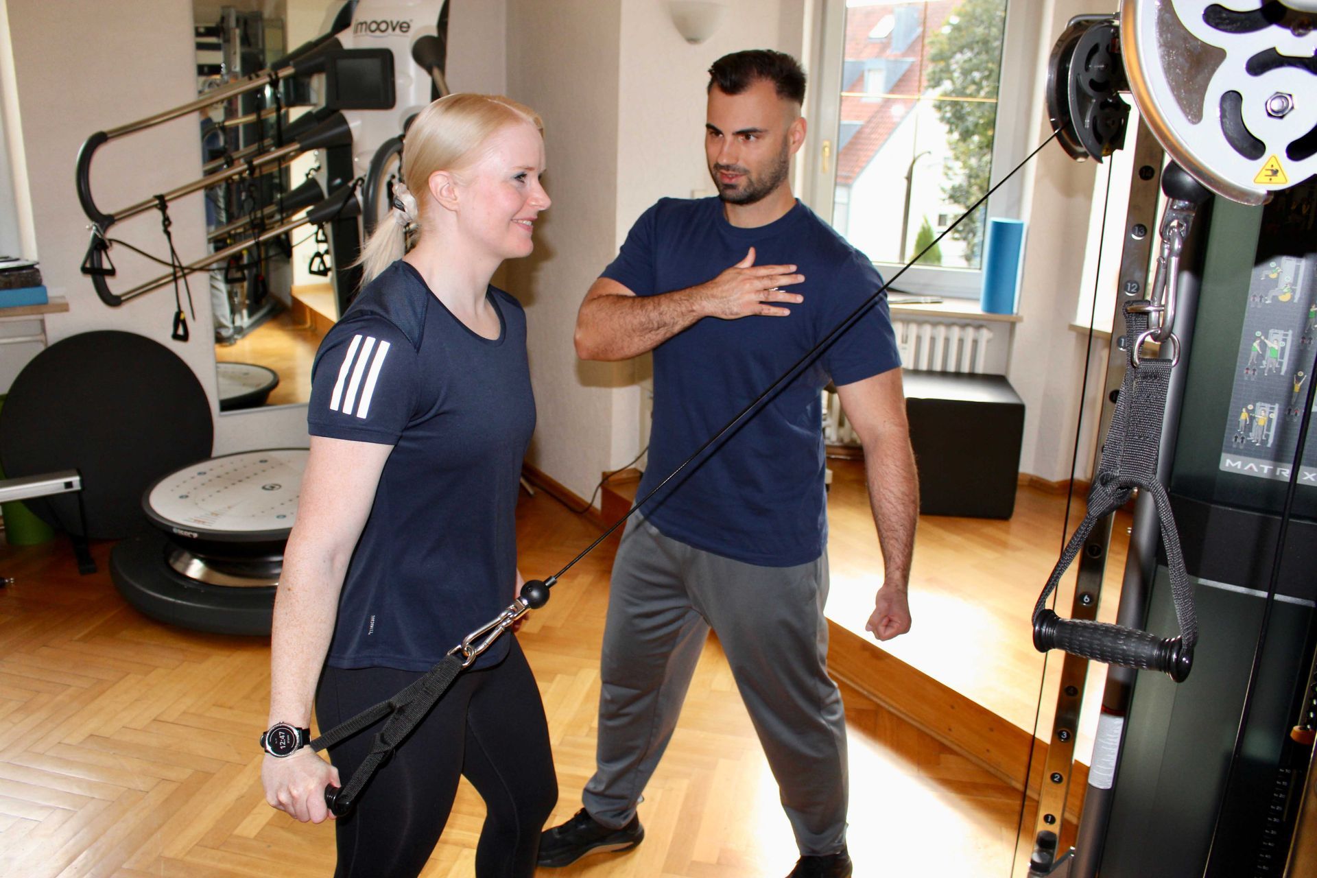 Konstantin Rasev motiviert eine Kundin im Fitnessstudio.
