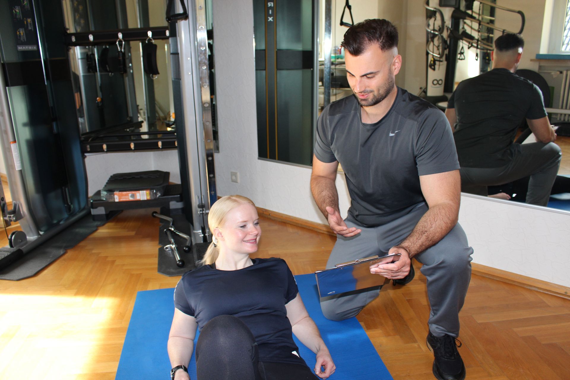 Konstantin Rasev motiviert eine Kundin im Fitnessstudio.