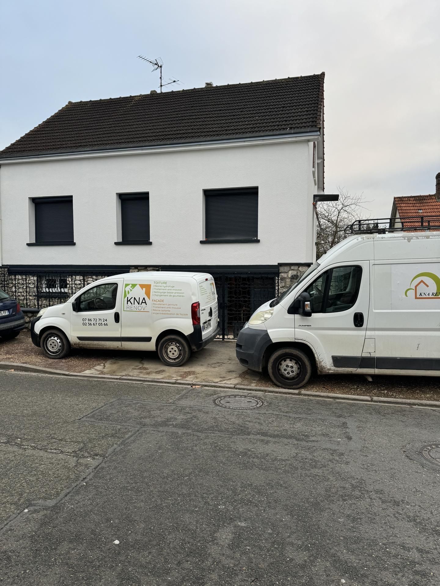 Deux camions devant une maison.