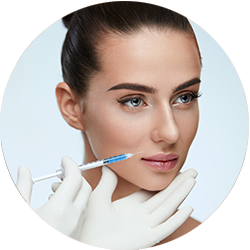 Mujer recibiendo una inyección cosmética en la zona de la mejilla con una mano enguantada.