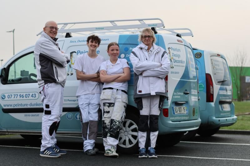 Équipe de l'entreprise Peinture Design Décoration adossé à un véhicule.