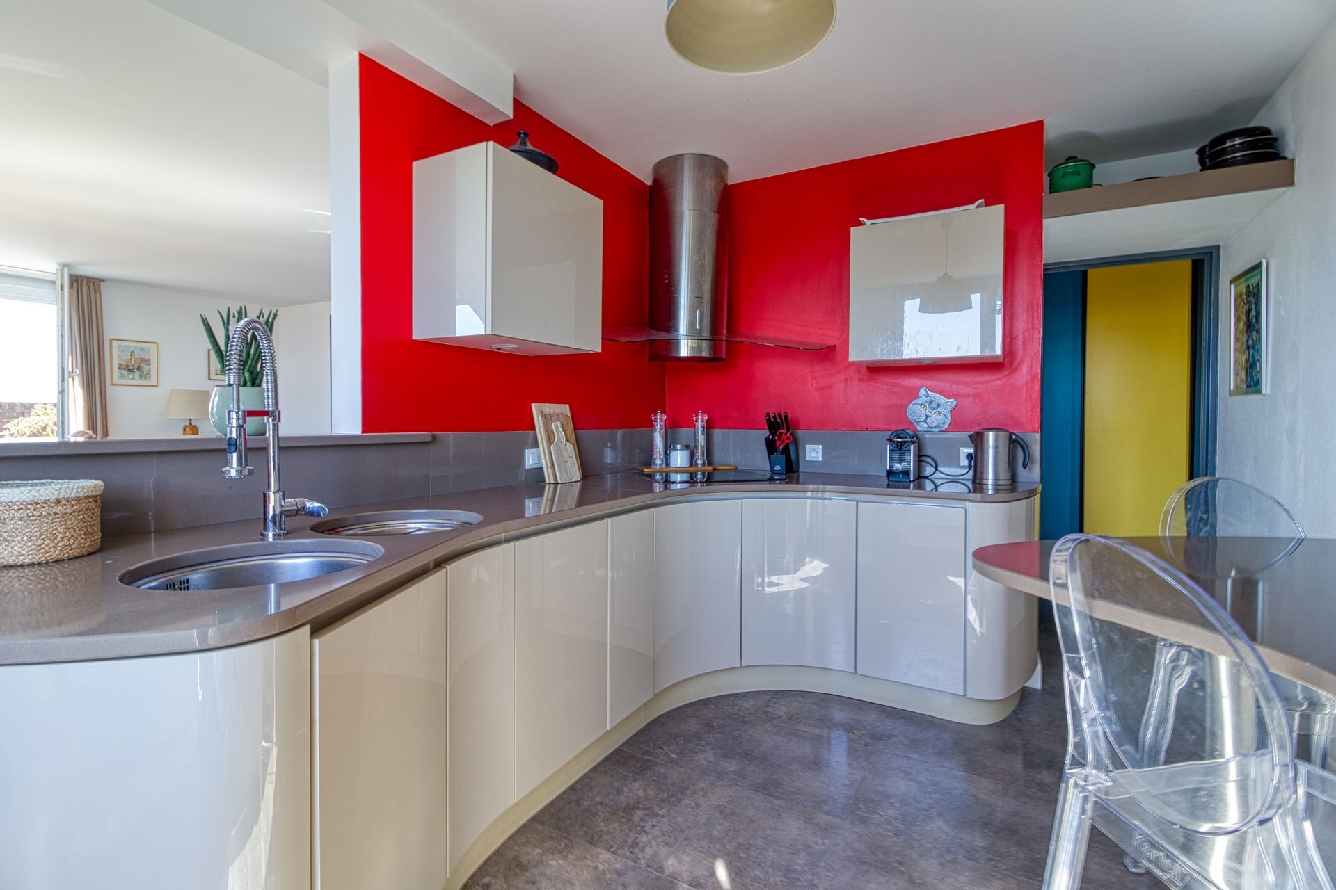 Une cuisine avec un mur rouge.