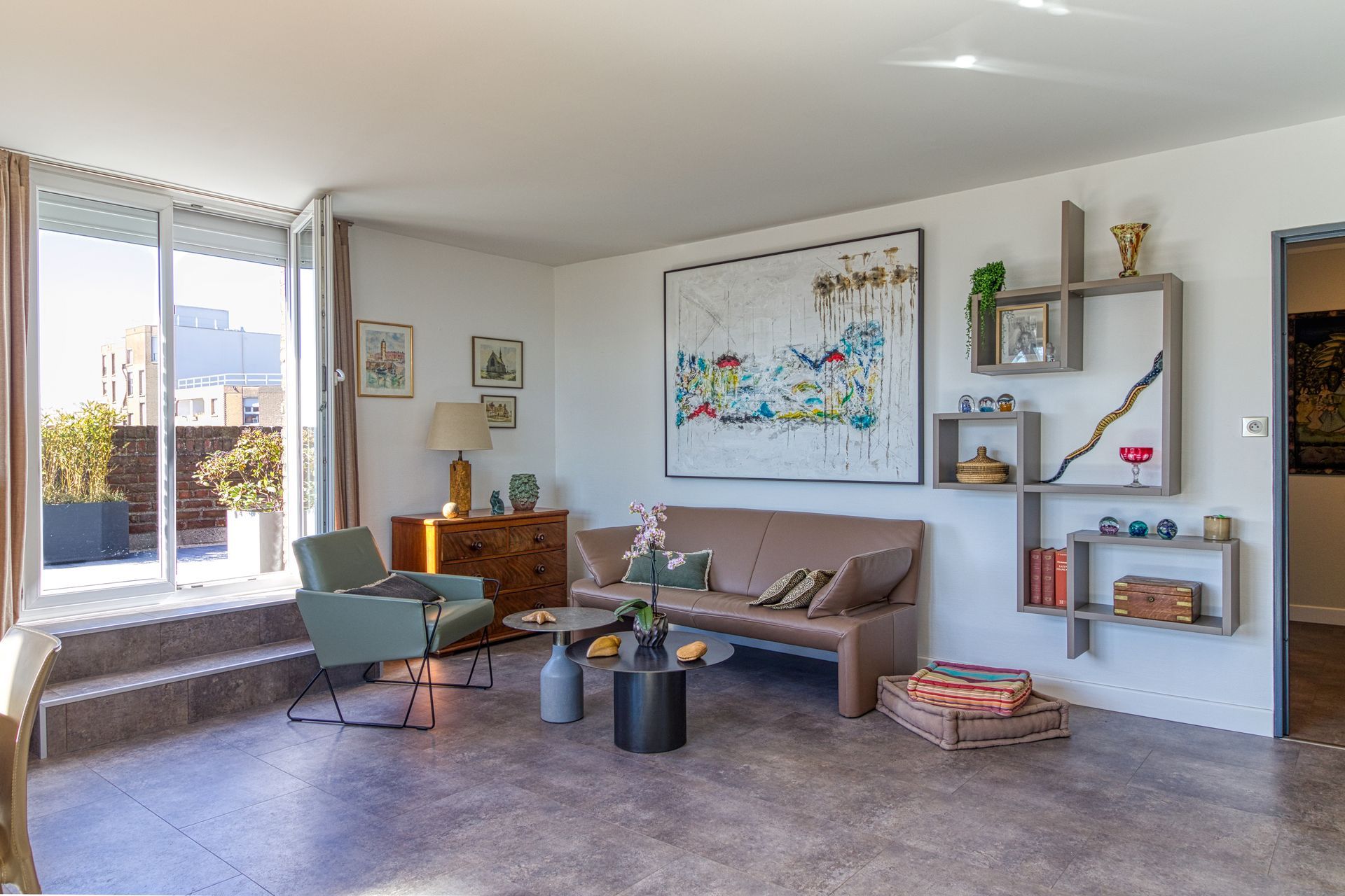 Un salon avec un grand tableau.