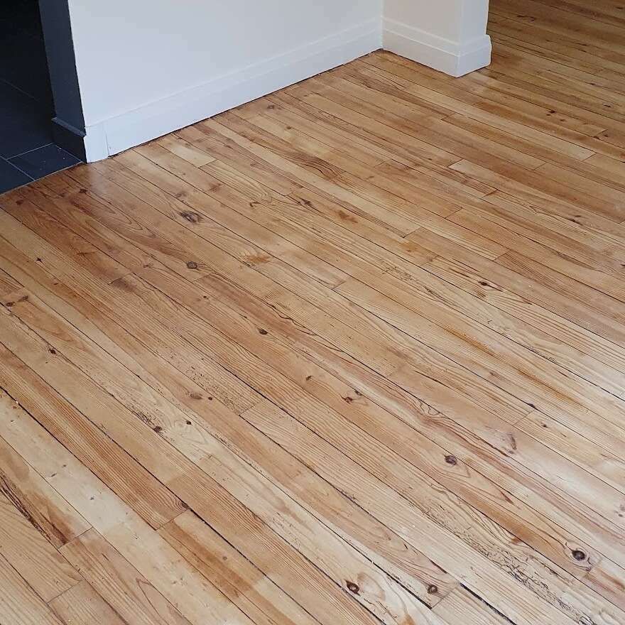 Un parquet et un mur blanc.