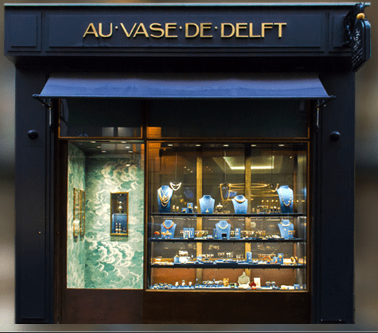 Façade du magasin Au Vase de Delft présentant une façade bleu foncé avec des lettres dorées et une vitrine remplie de bijoux.