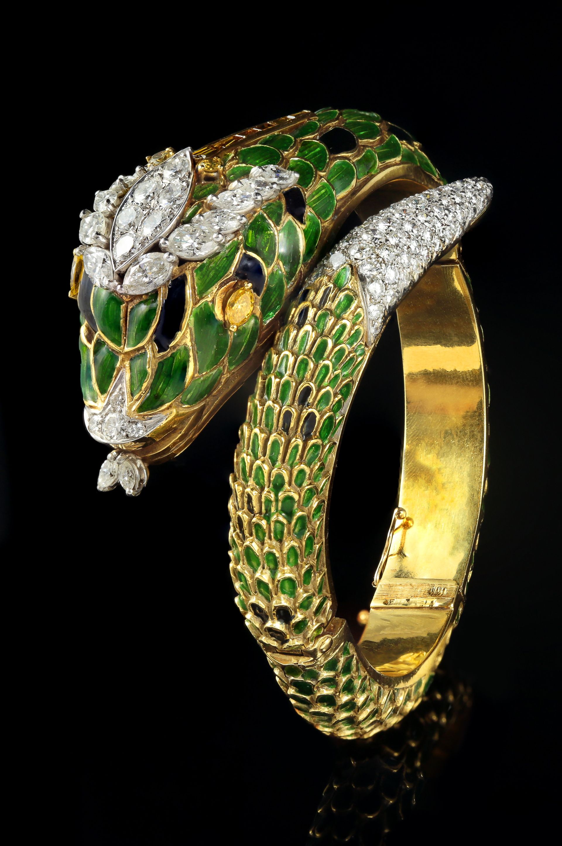 Bracelet serpent en or avec écailles en émail vert, ornements en diamant sur la tête et la queue, et fond noir.