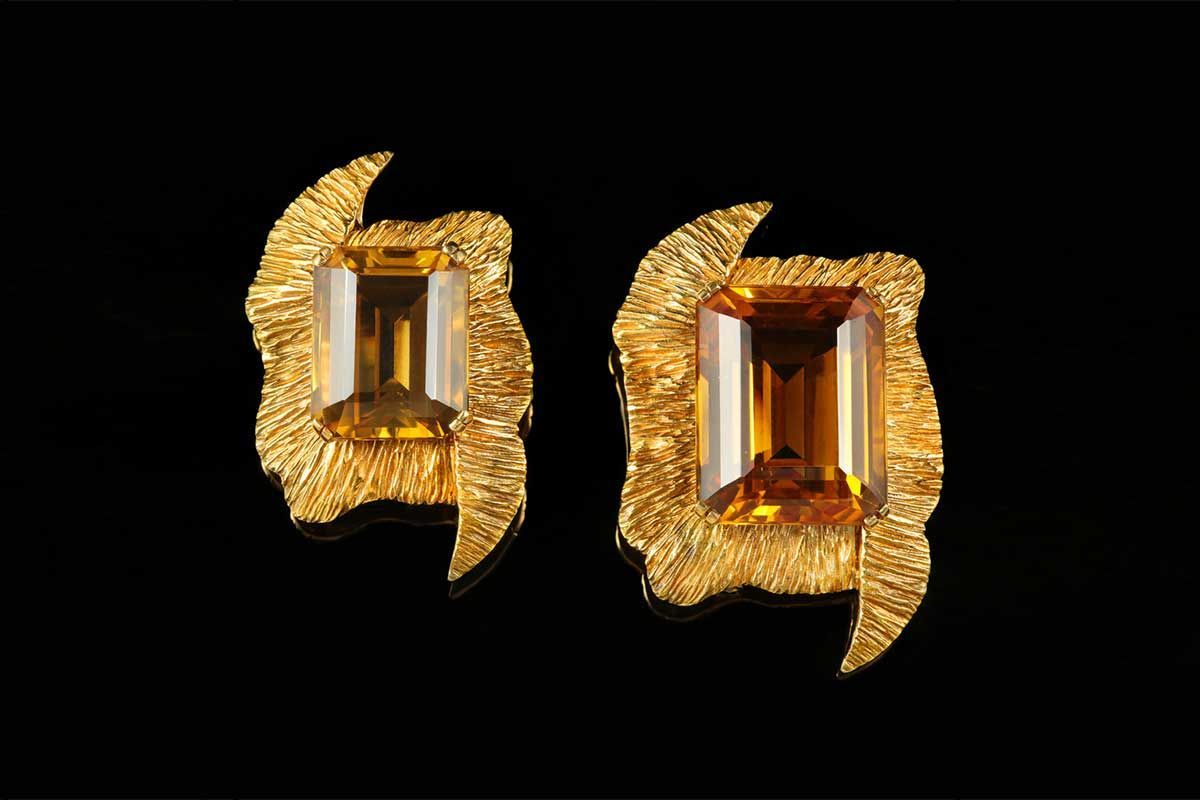 Une paire de boucles d'oreilles en or, chacune ornée d'une grande pierre précieuse rectangulaire de couleur ambre, sertie dans une monture en or texturée et organique.