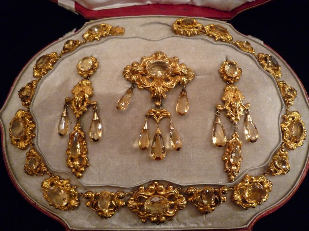 Un ensemble de bijoux en or de style victorien orné de pierres précieuses ambrées, comprenant un collier, une broche et deux boucles d'oreilles pendantes.