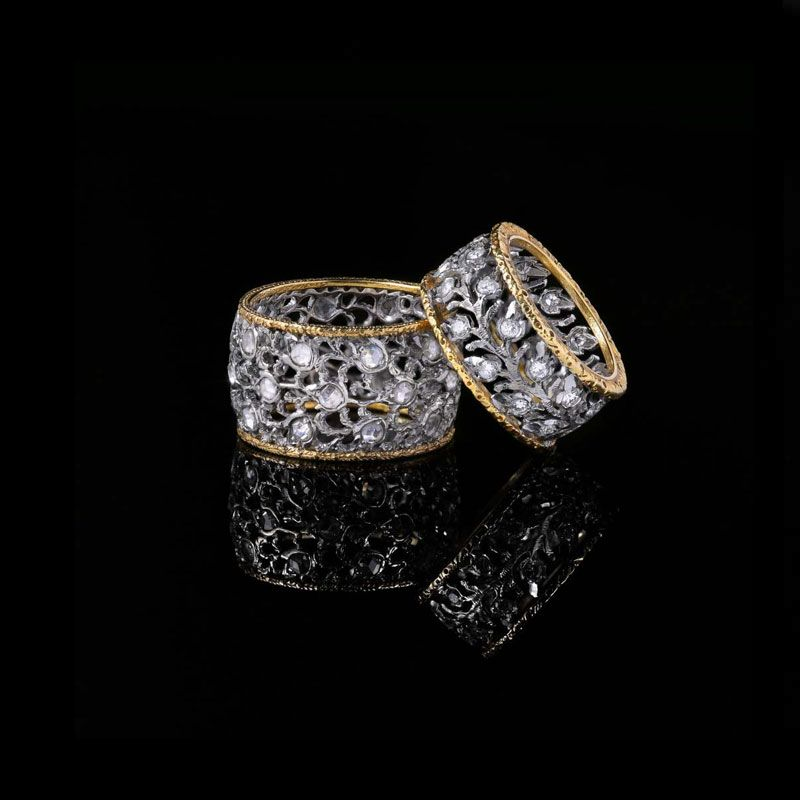 Deux bagues ornées, cerclées d'or, présentant un travail du métal complexe de style filigrane serti de pierres transparentes étincelantes.
