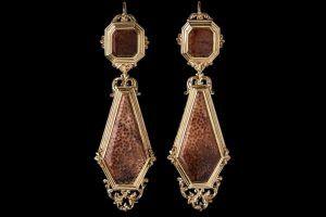 Une paire de boucles d'oreilles pendantes vintage en or avec des incrustations de pierres brunes mouchetées, octogonales et allongées en forme de cerf-volant.