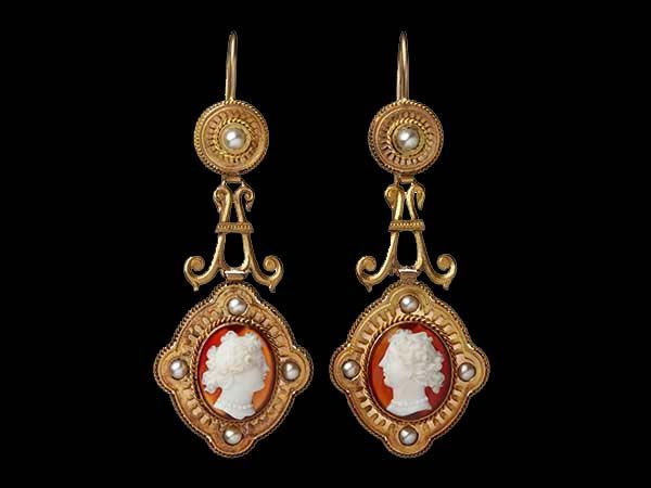 Une paire de boucles d'oreilles en or texturé ornées de pierres précieuses couleur miel de taille rectangulaire, centrées sur un fond noir.