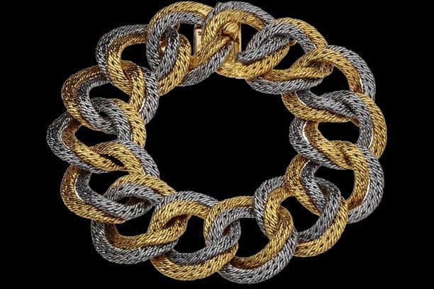 Un bracelet composé de maillons texturés or et argent entrelacés, disposés en cercle sur fond noir.