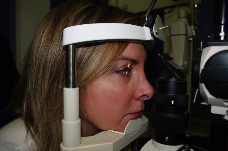 Una donna si sta facendo visitare gli occhi da un oculista