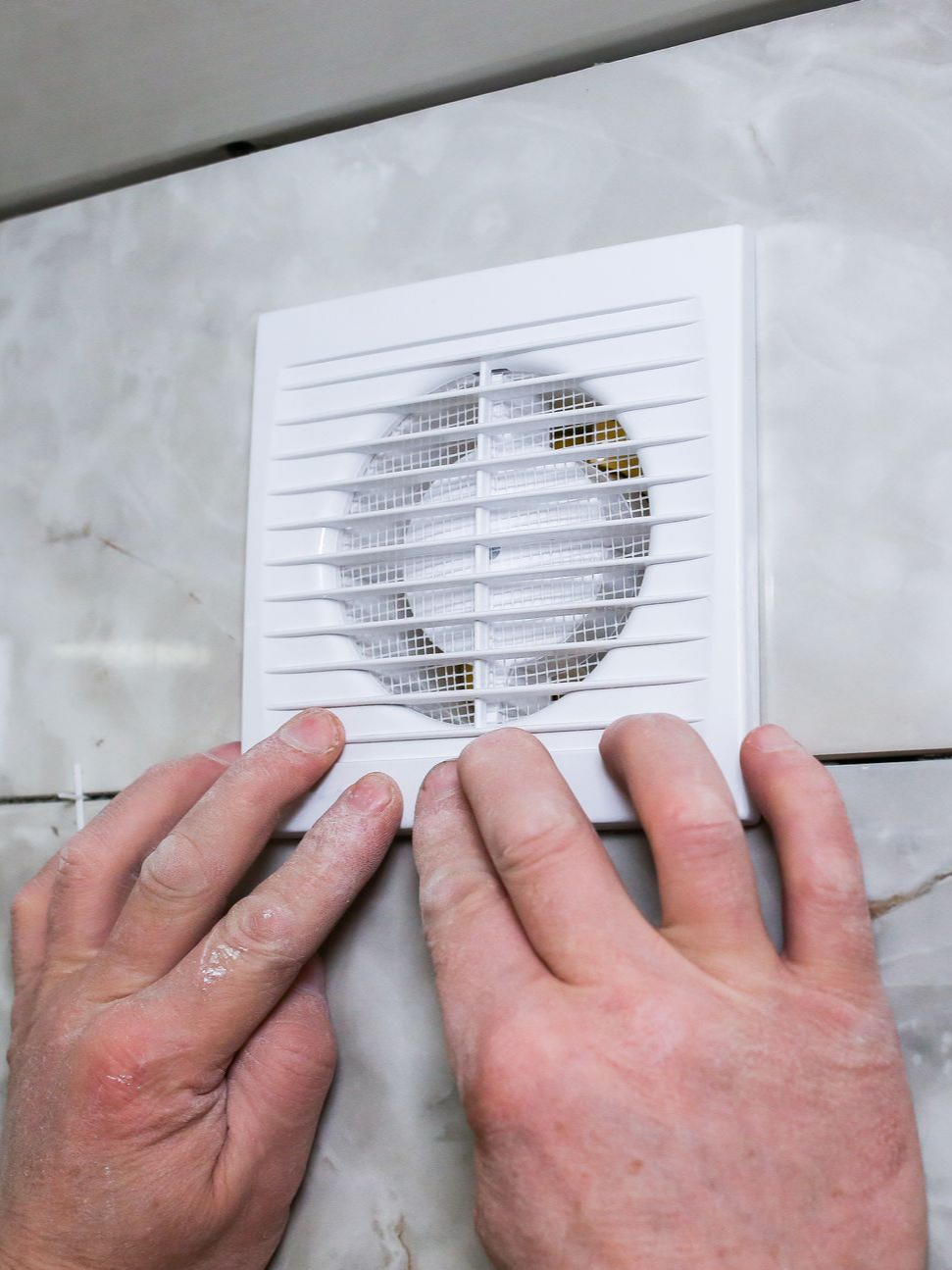 Pose d'une bouche d'aération dans une maison