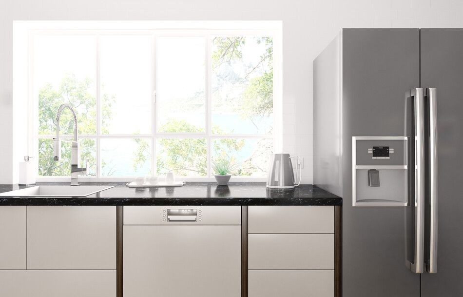 Una cocina con frigorífico, fregadero, lavavajillas y ventana.