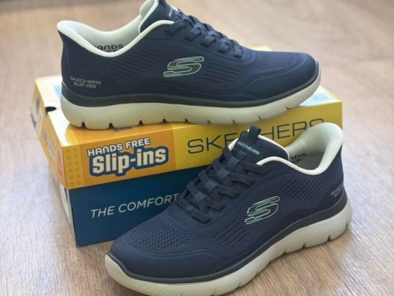 Paire de baskets Skechers bleu marine à enfiler, sur une boîte à chaussures.