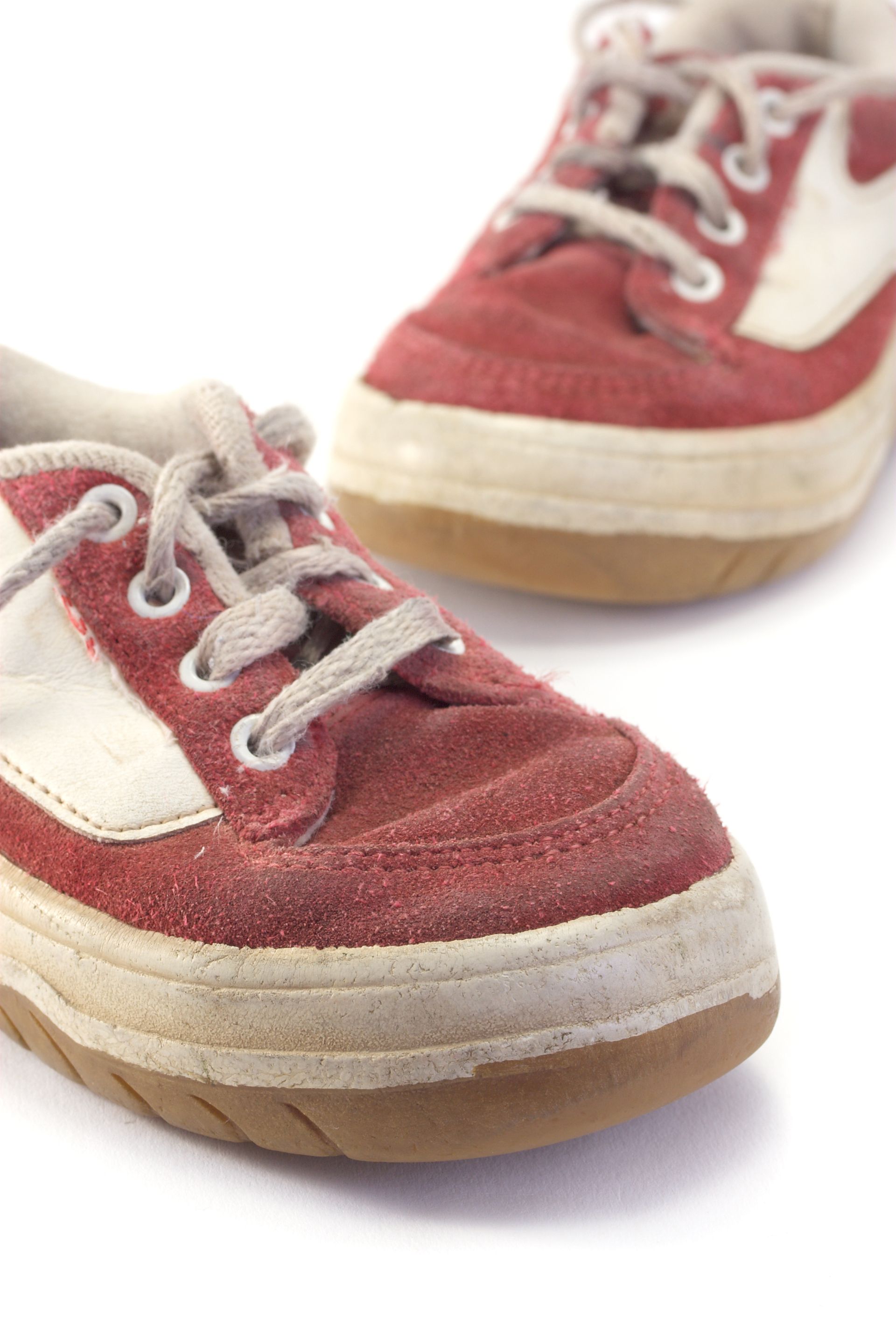 Deux baskets rouges à lacets blancs et semelles en gomme sur fond blanc