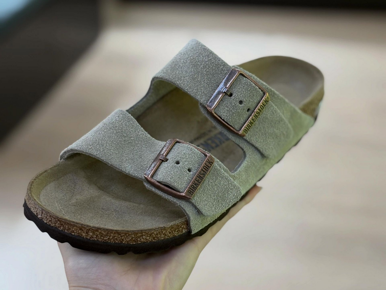 Sandale en daim vert clair avec deux brides à boucle sur le pied.