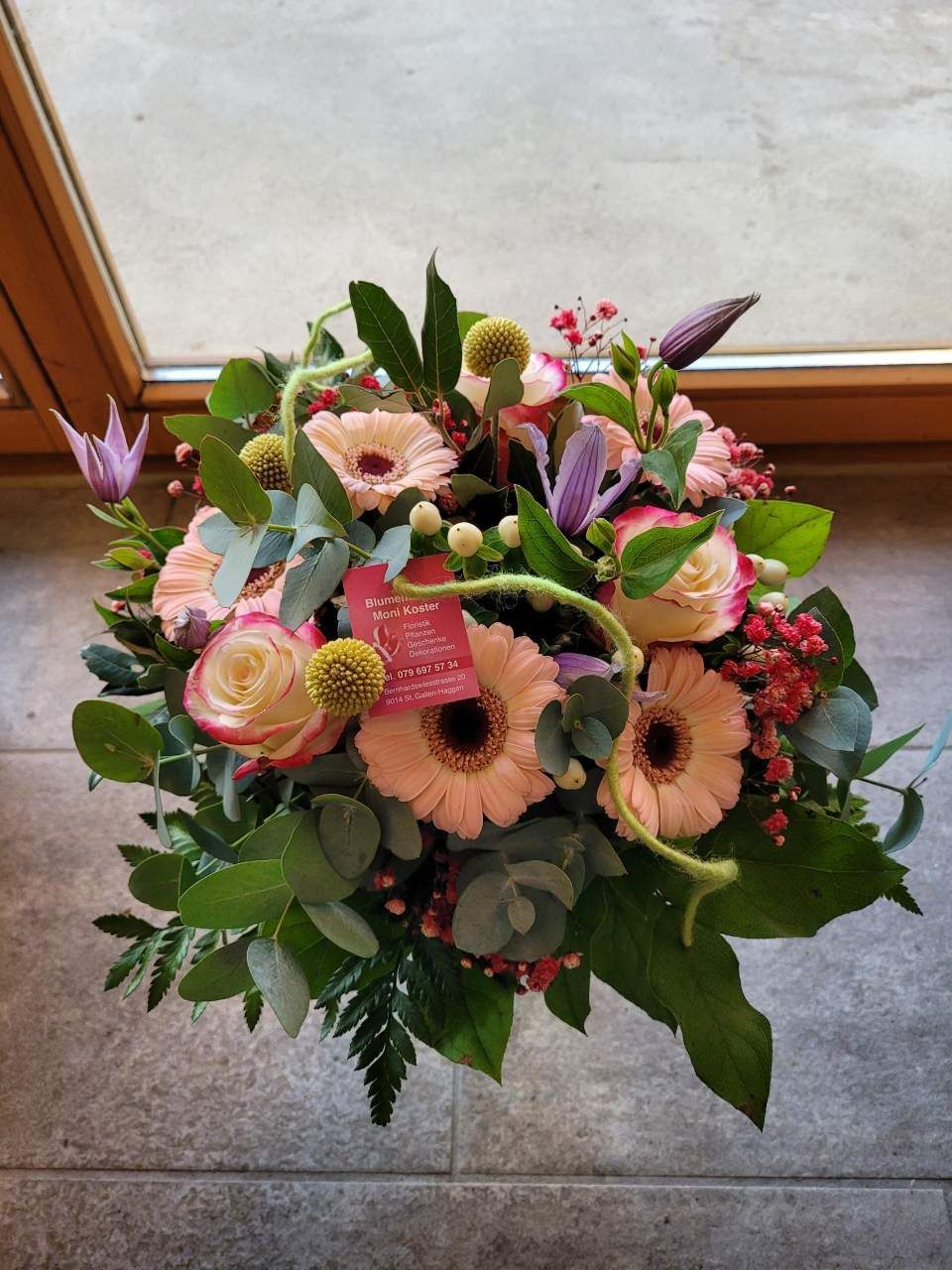 Ein Blumenstrauss steht vor einem Fenster. Foto vom Blumenatelier, Moni Koster