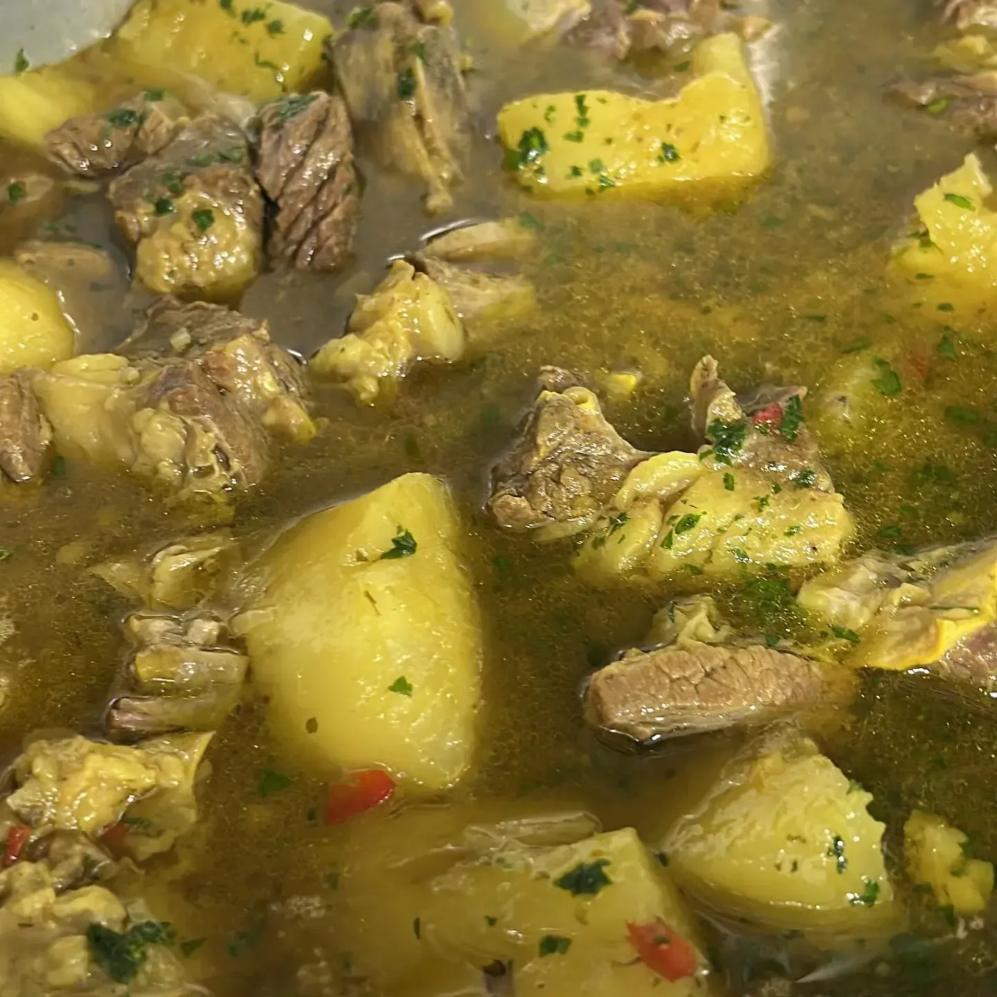 Guiso con carne, patatas y hierbas en un caldo ligero.