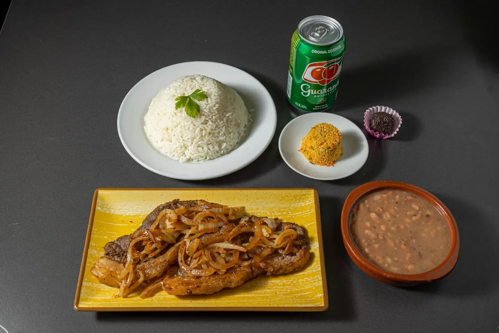 Plato con un panecillo y un bocadillo de pollo frito sostenido por una persona.