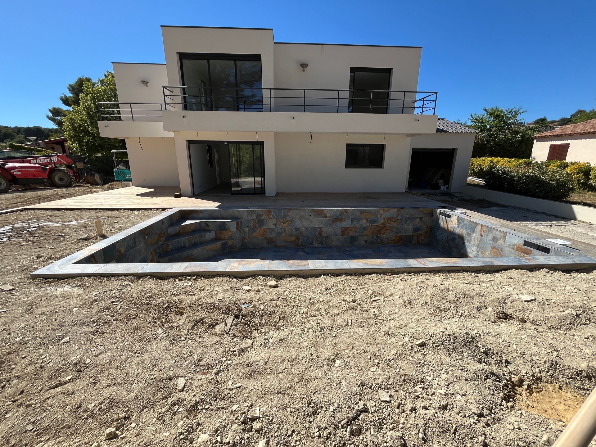 Une maison blanche à deux étages avec une piscine en construction
