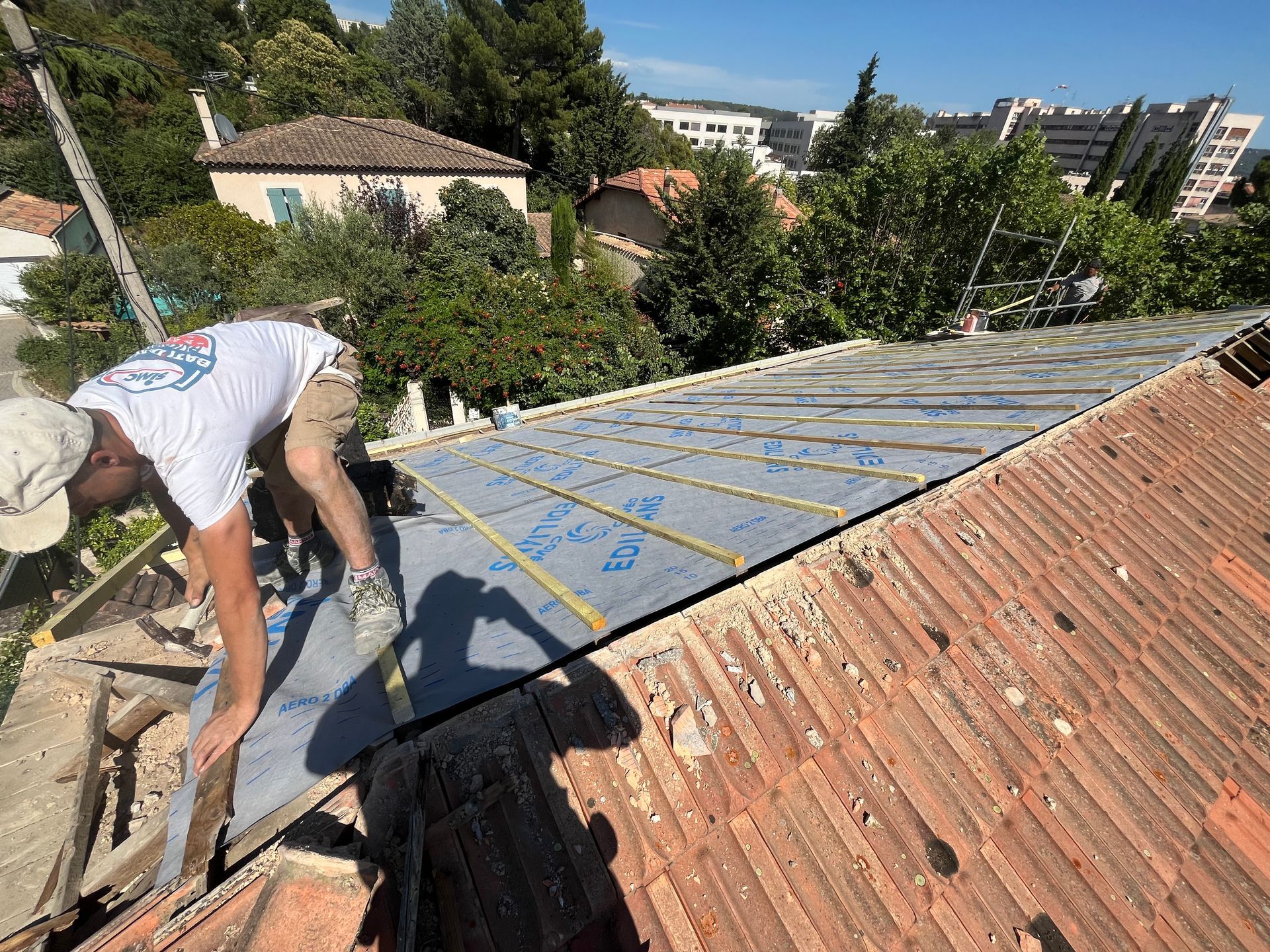 Couvreur installant de l'isolant sur un toit