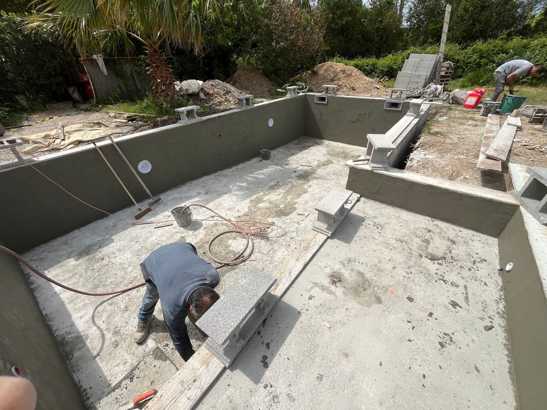 Des ouvriers construisent la structure de la piscine