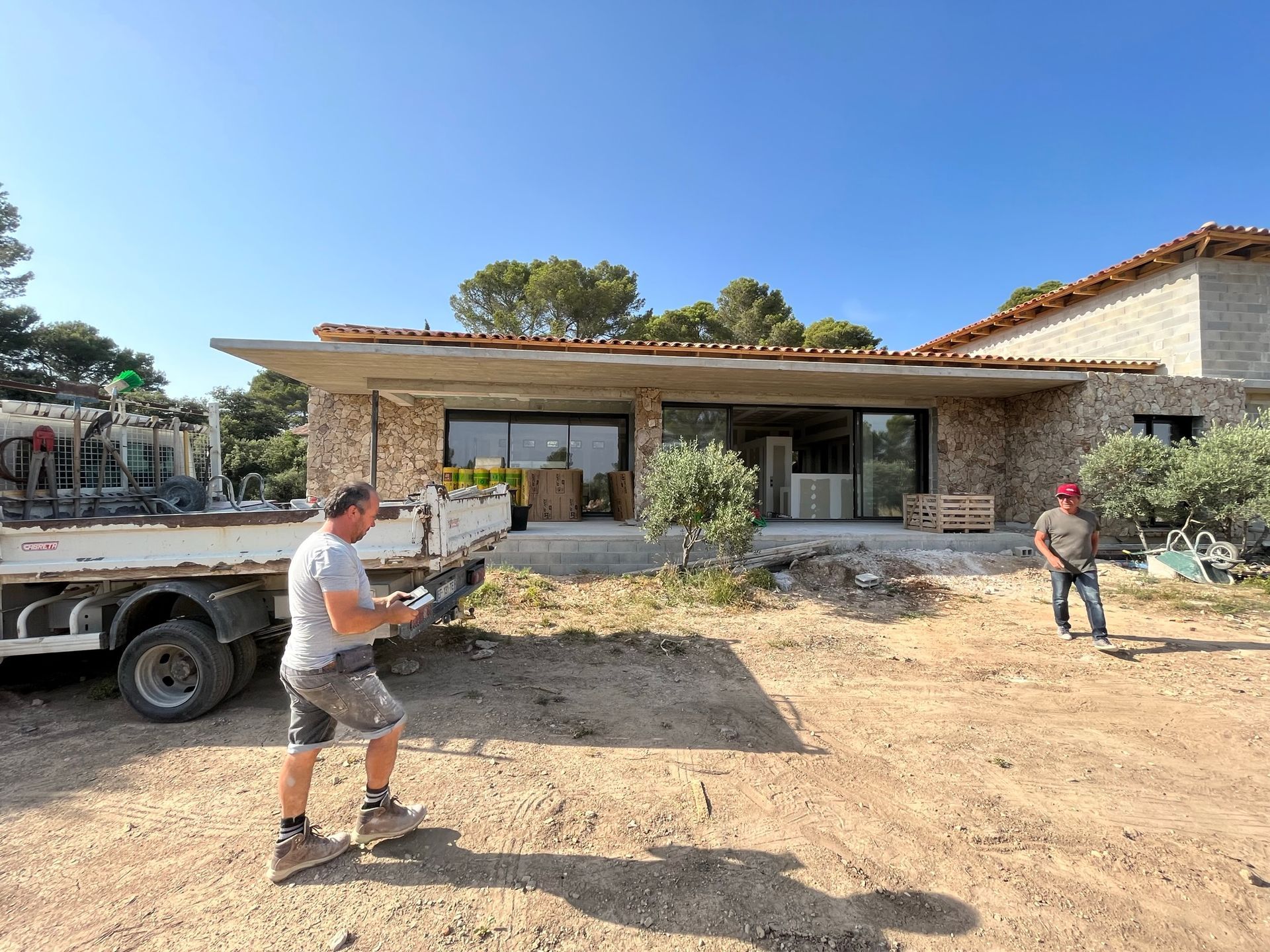 Deux hommes travaillent sur une maison en pierre