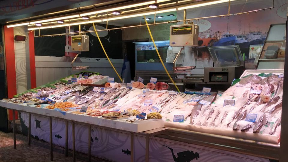 Un mercado de pescado con mucho pescado en exposición.