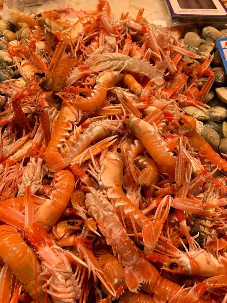 Un montón de camarones y almejas sobre una mesa.