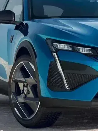 Detalle de la rueda delantera y el faro de un SUV eléctrico azul