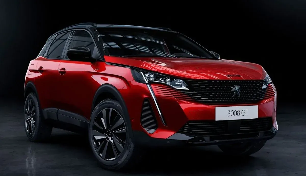 SUV compacto rojo con techo y ruedas negras sobre un fondo de estudio oscuro.