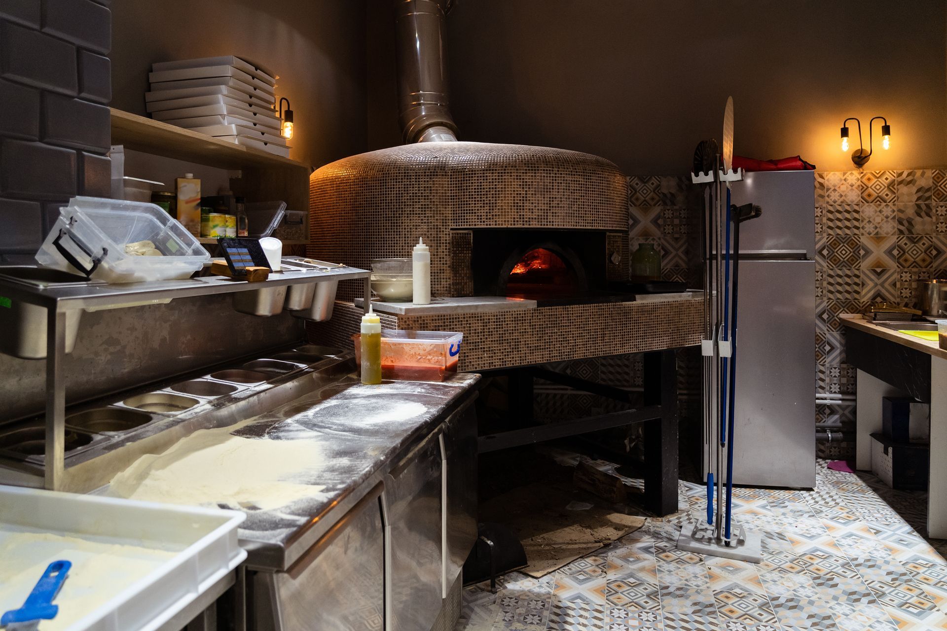 Four à pizza dans la cuisine d'un restaurant avec zone de préparation de la pâte.