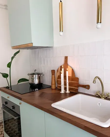 Una cocina con un fregadero y una olla en la estufa.